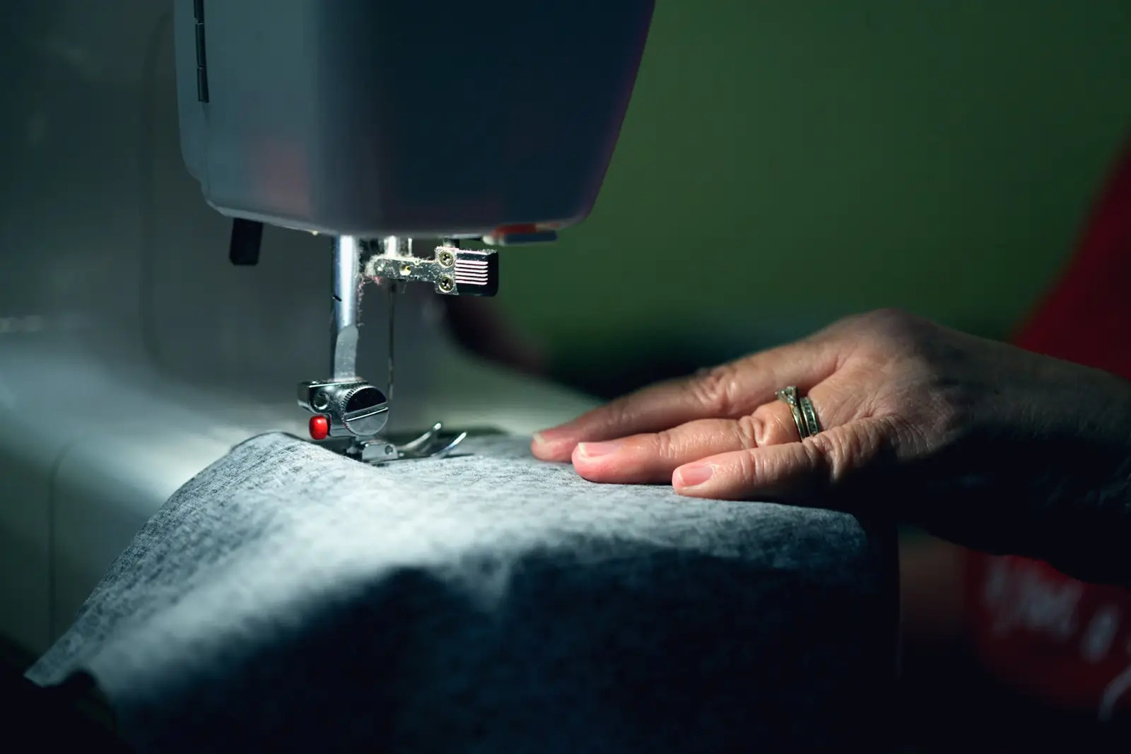 Mains guidant un tissu sous une machine à coudre